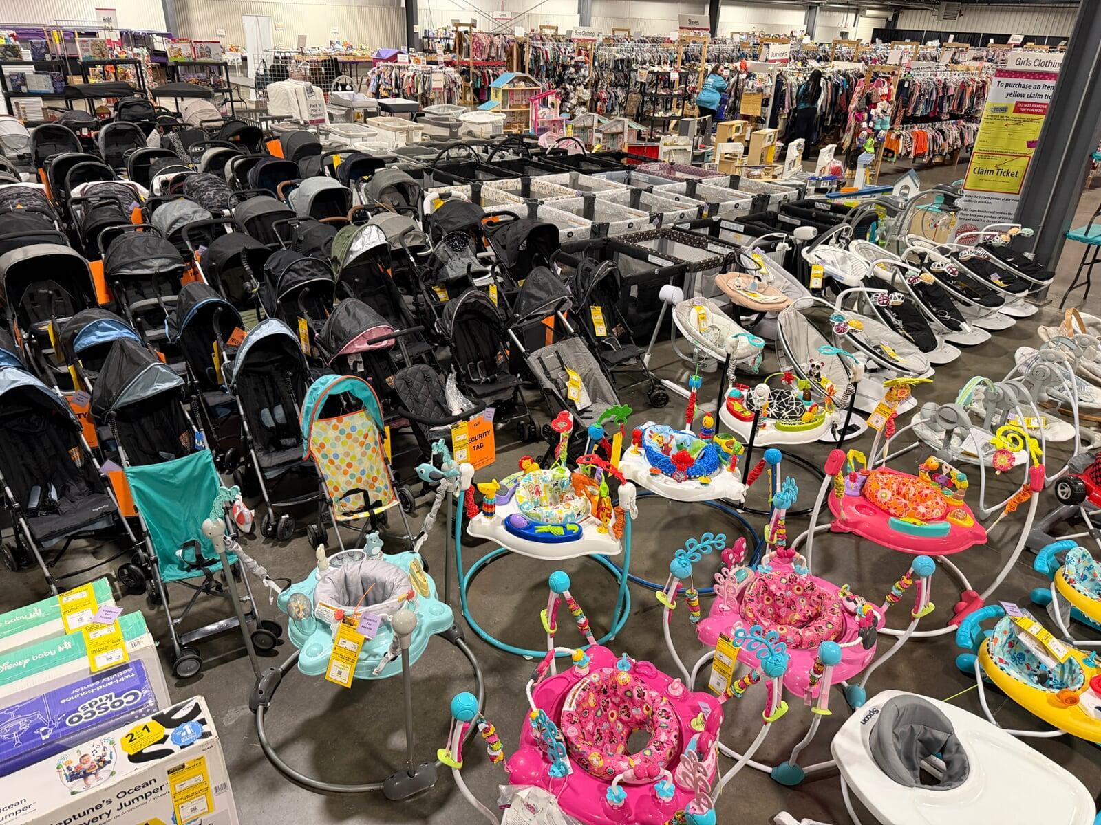 A mom and her child hug in between two rows of little girl clothes